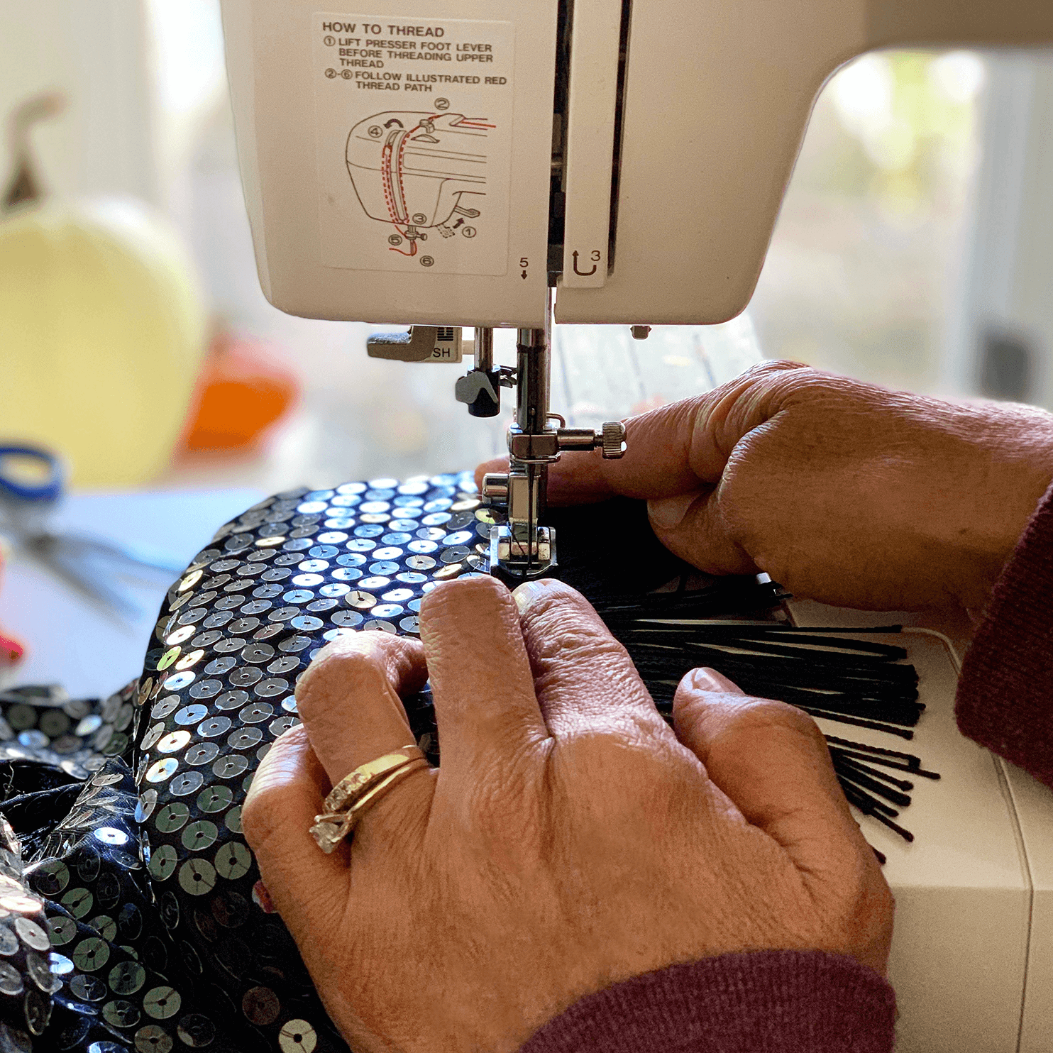 Lisa cosiendo vestido de lentejuelas a mano en su atelier de Madrid